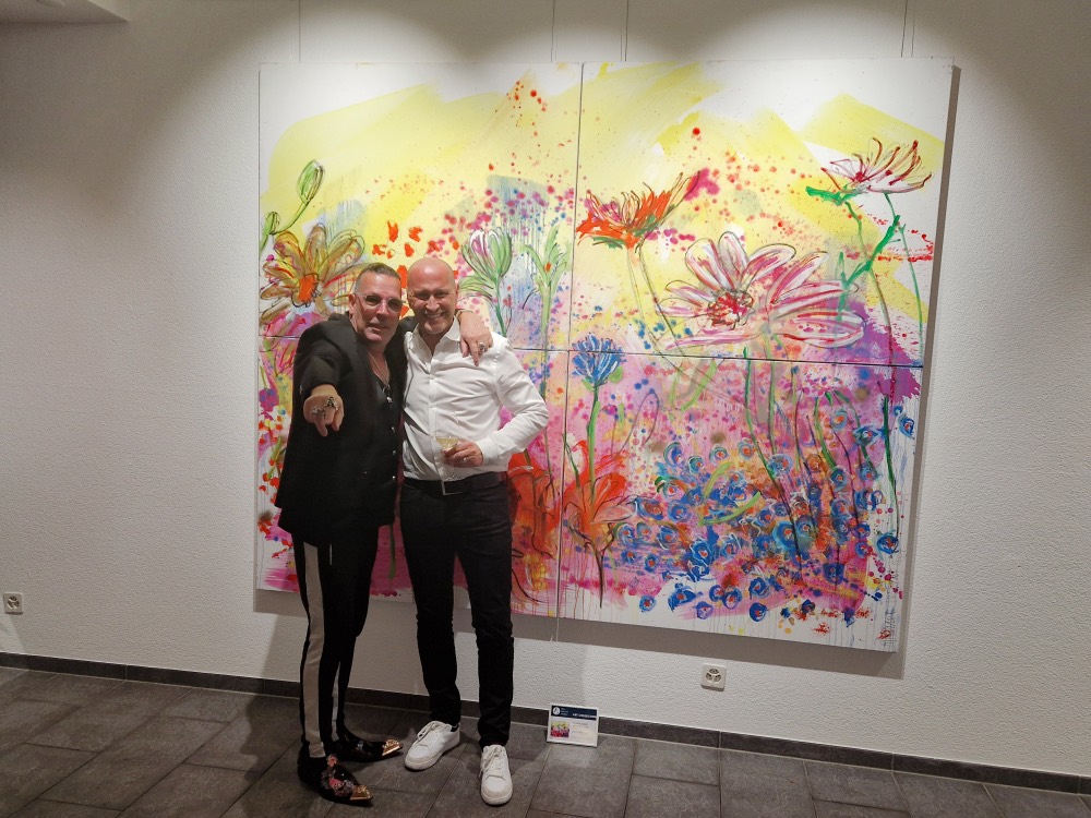 Künstler vor einem Werk in der Galerie